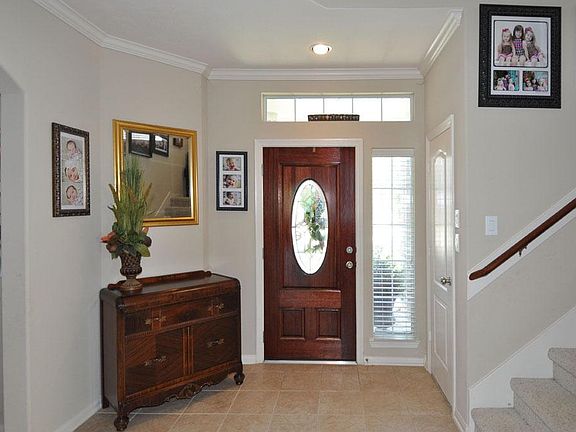 Beautiful tile entry with crown moulding, neutral colors and a hall closet that boasts tons of storage.