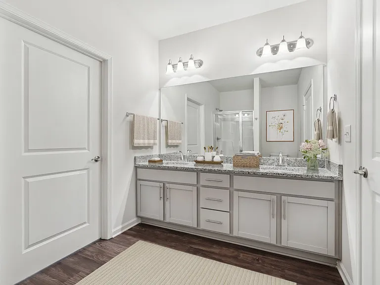 Primary bathroom with double vanity, walk-in shower and walk-in closet.