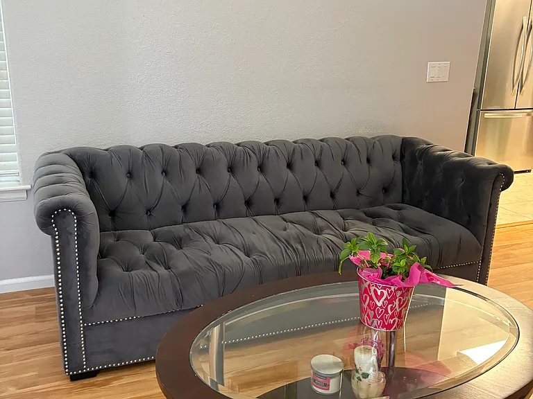 Dining room, living room is furnitured with basic table, chairs, sofa and coffee table.