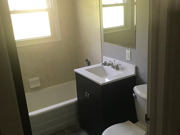 New toilet, sink/vanity, floor, mirror and lighting