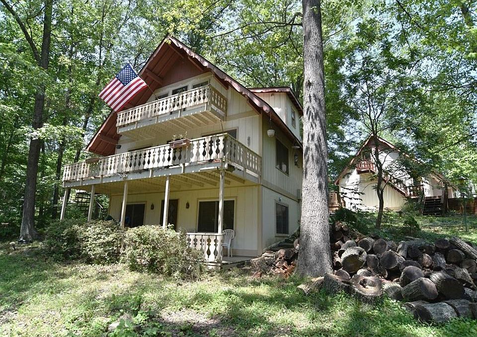 Front of Lakefront Chalet Home with Sleeping quarter above 3 Car Garage on right.