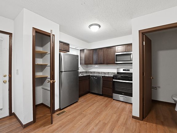 The Kirchen area with a pantry, stainless steel appliances, and the door to the rear patio. The main floor 1/2 bathroom is off the kitchen.