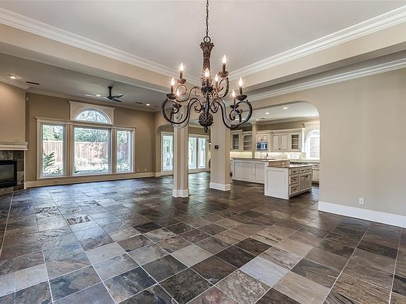 This view shows the Chef's Kitchen open to LR/DR with Breakfast area on other side opening to Sunroom and then into backyard. Imagine entertaining in this area! 10' ceilings throughout the 1st floor with crown moldings, custom millwork, custom cabine