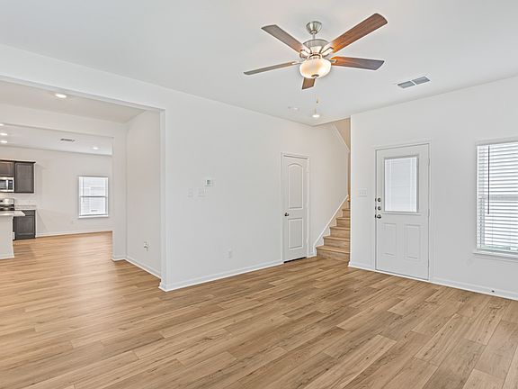 Open family room, with the staircase leading upstairs and a door leading outside.