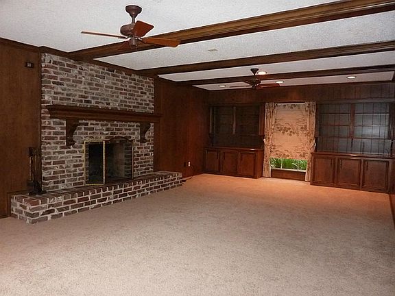 Huge den with gas fireplace and wet bar extends from the front to the back of the house