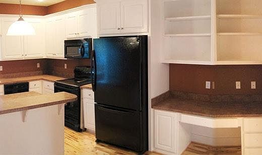 Desk nook and cabinets adjacent to kitchen