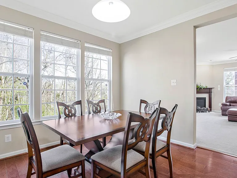 The bay window brings the outdoors in, filling the dining room with natural light and peaceful tree-lined views.