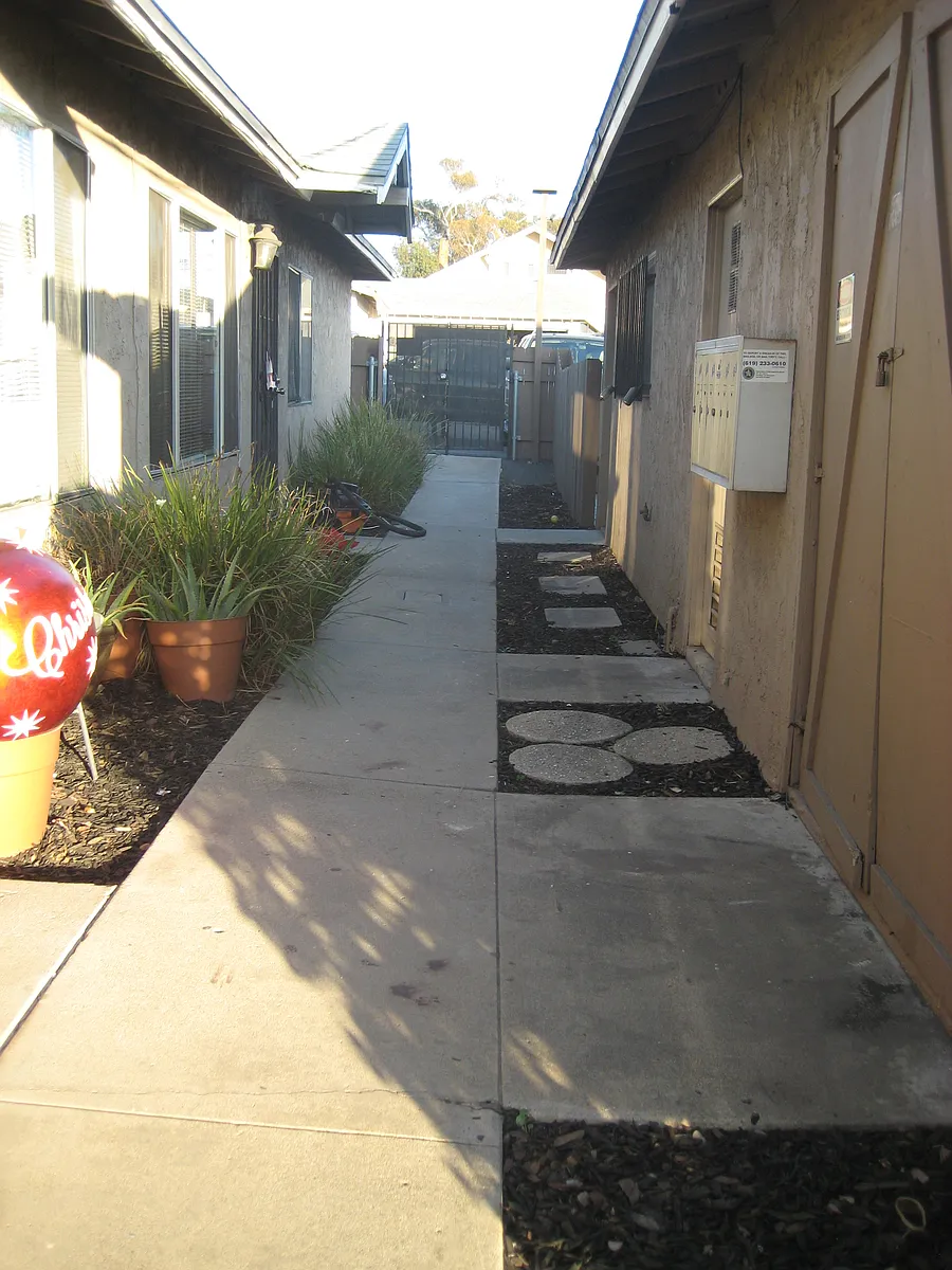 Walkway to the front gate from the inside. All units are enclosed by fencing and a patio in back. - Division St