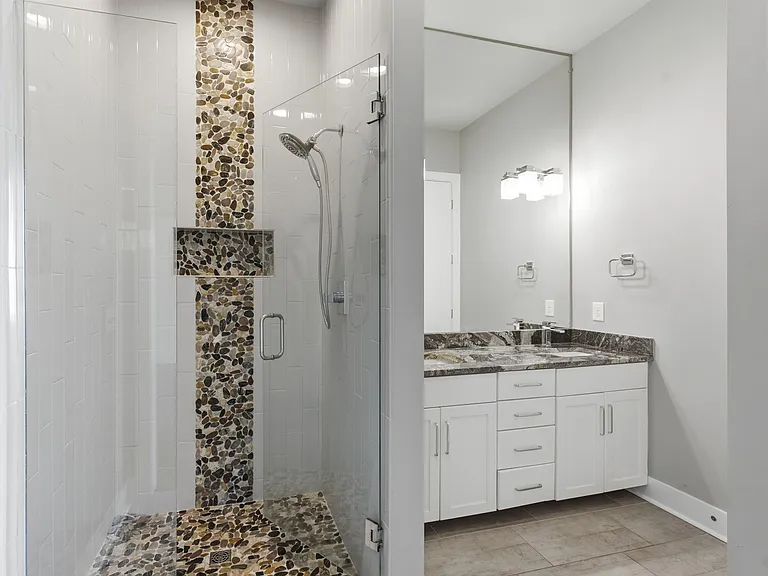 Master bathroom has a large tiled shower, tile floors and double sinks