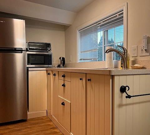 Sink with Spacious Countertop and Lots of Storage. Cabinets have Bowls, Plates, Utensils and Drinking Cups.