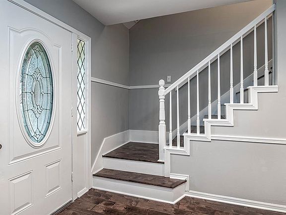 Upon entering you find a welcoming corridor showcasing custom paint, beautiful floors, and the staircase to the second floor!