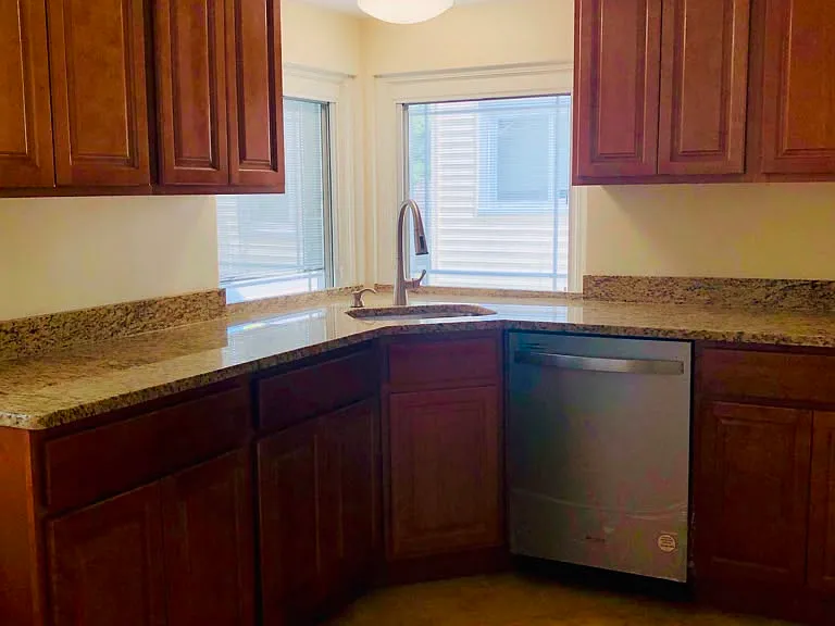 Renovated kitchen with new cabinets, granite countertops, sink, dishwasher & stove