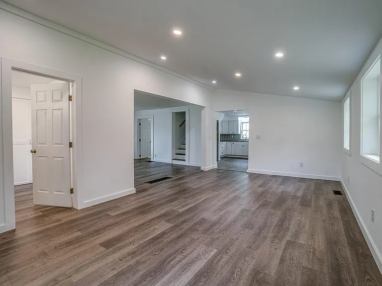 Dining room with view of kitchen and stairs to upper two newly painted bedrooms. Door to bathroom on left.