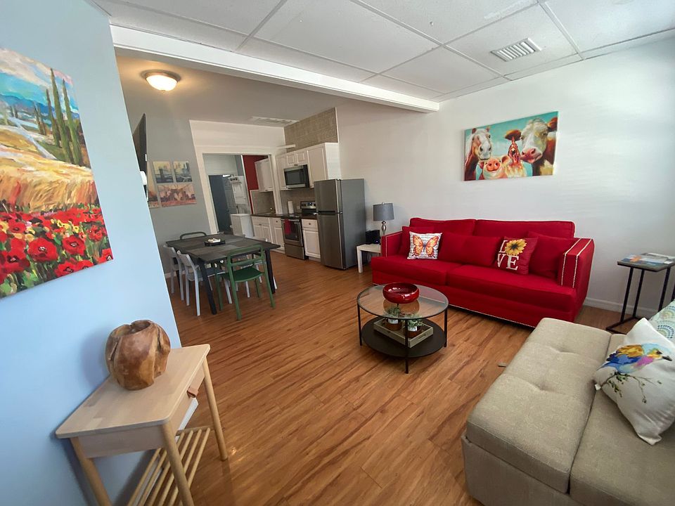 Cozy and bright living room with coffee tables, decorative paintings, a large sofa and a medium-sized sofa