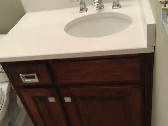 Mater and guest vanities with quartz countertops and chrome faucets, mirror and light fixture.