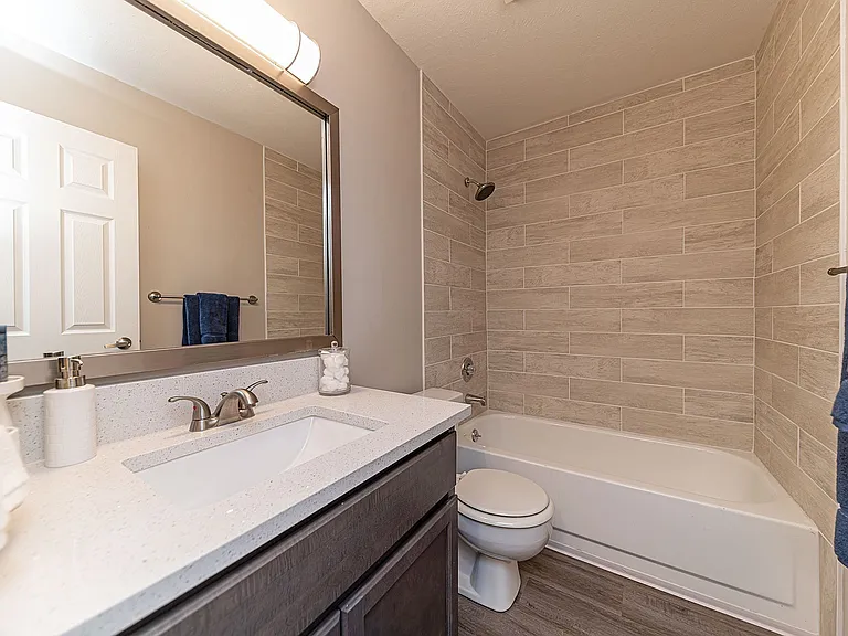 Bright bathroom with granite counters and bathtub