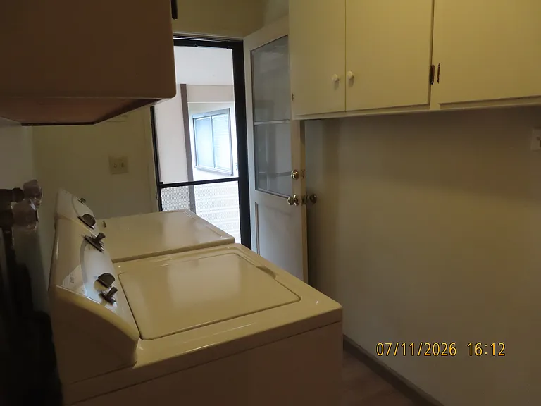 Laundry room with storage cabinets washer and dryer.
