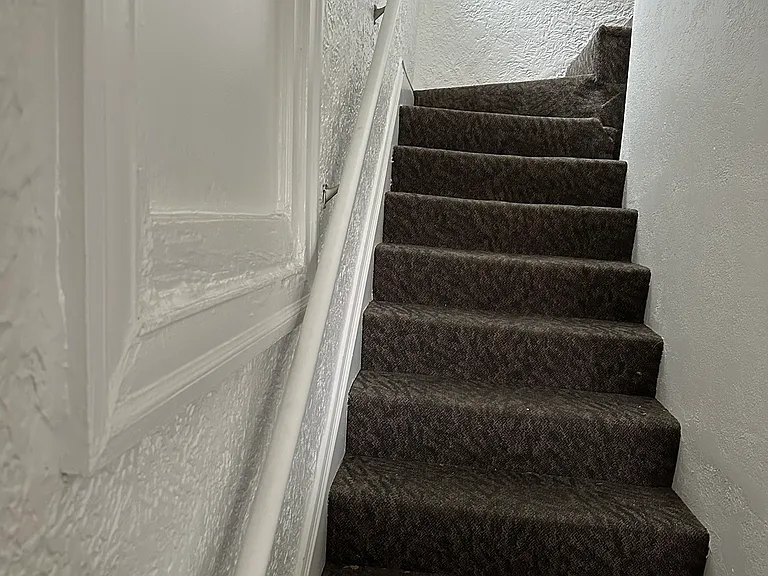 Stairs to the unit from the shared front door entrance.