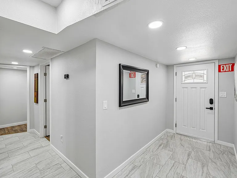 Inviting entry hallway with durable tile flooring, recessed lighting, and direct access to adjacent rooms and the main door.
