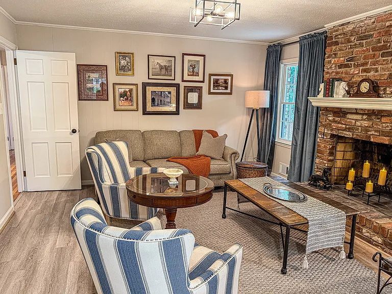 The great room features comfortable seating, a fireplace, a dedicated workspace, and a 65-inch smart TV.
