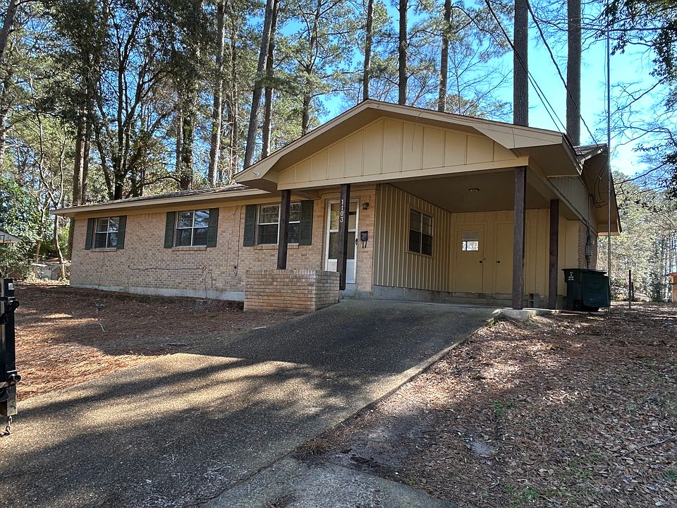 Front of house with cover for vehicle.