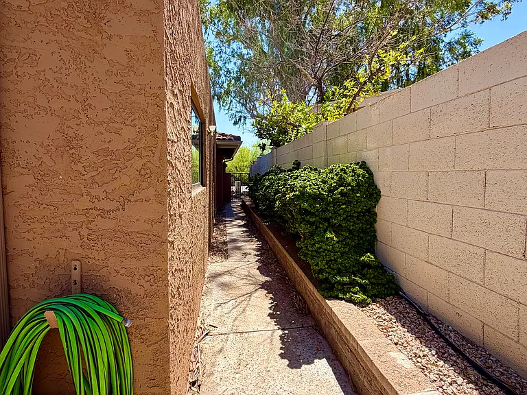 Side of backyard looking towards front of house. This is the only exterior entrance to the backyard.