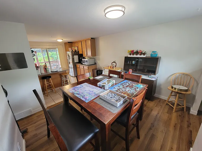 Dinning room with kitchen behind and sliding door to backyard deck
