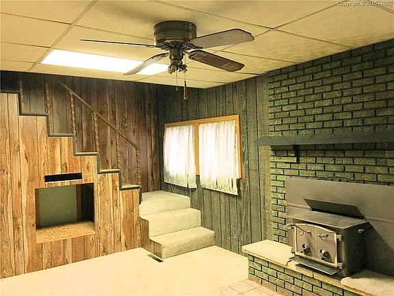 Living room with Pellet stove on a raised brick hearth. Opening under the stairs