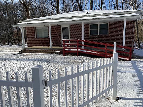 There are stairs on each end of the covered porch as well as a wooden ramp