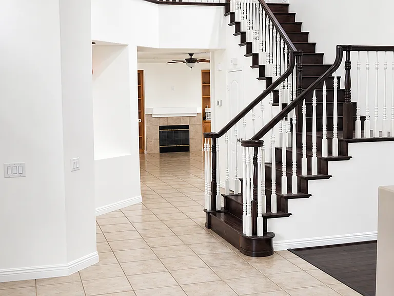 Elegant entry with dramatic staircase, tile flooring, and high ceilings