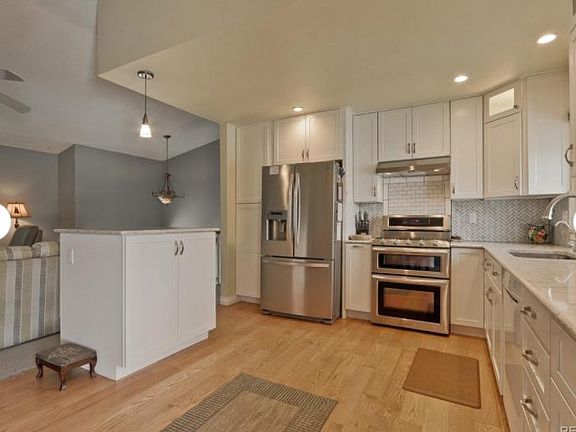 Updated eat-in kitchen with stainless steel appliances, hardwood floors, gas range with double oven and quartz countertops.