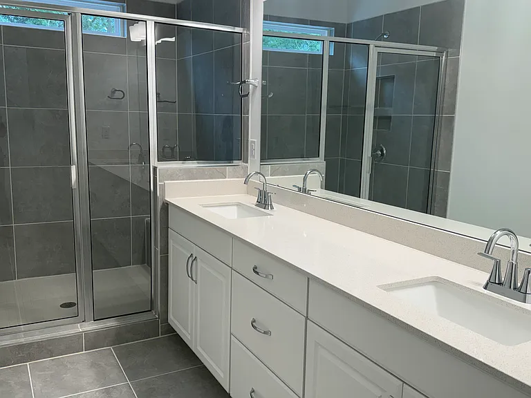 Luxurious primary bathroom with dual vanities and oversized walk-in shower.