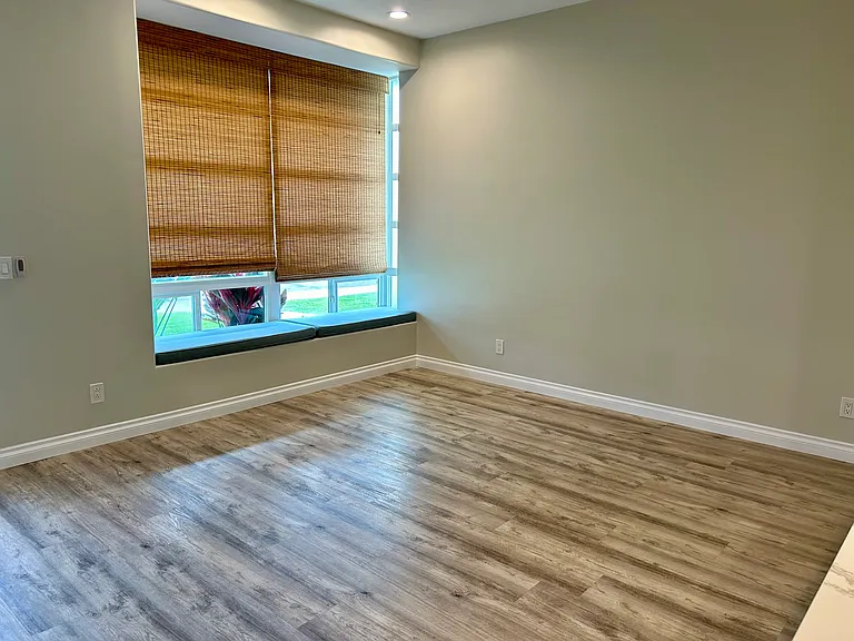 Great sized living room with bay window and cushions for extra seating.