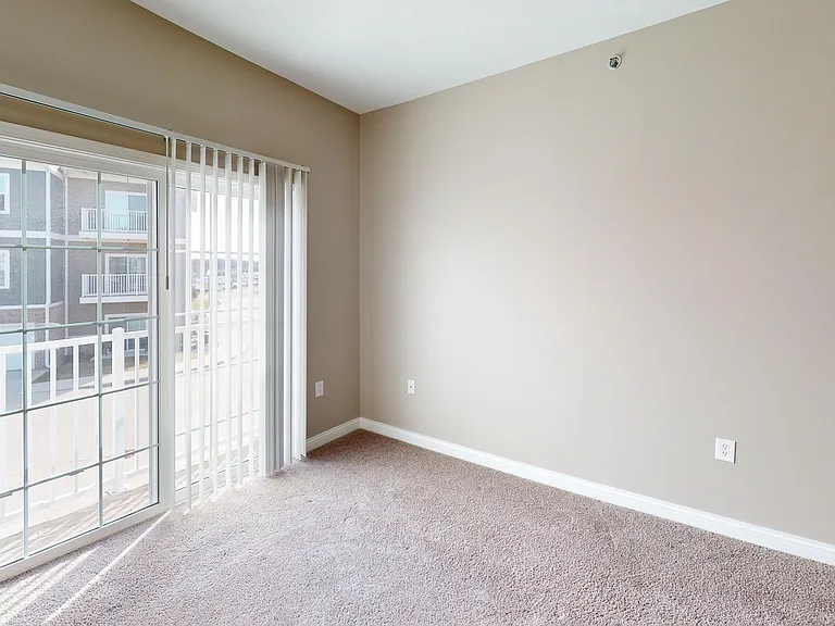 Soft carpet underfoot, fresh air just outside. This bedroom's private balcony brings in light, breeze, and a quiet escape.