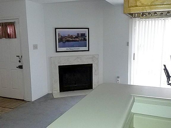 View of front door from interior, fireplace, door to outside patio