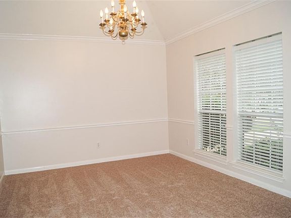 Formal dining has high ceiling, crown molding and chair rail.