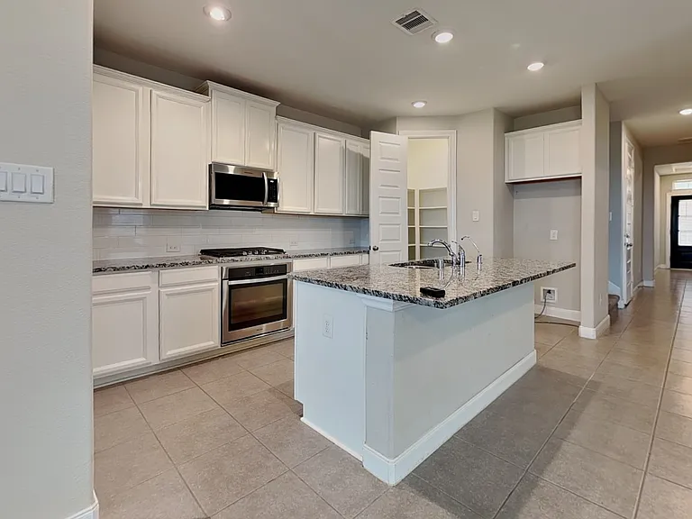 Spacious kitchen with white ca