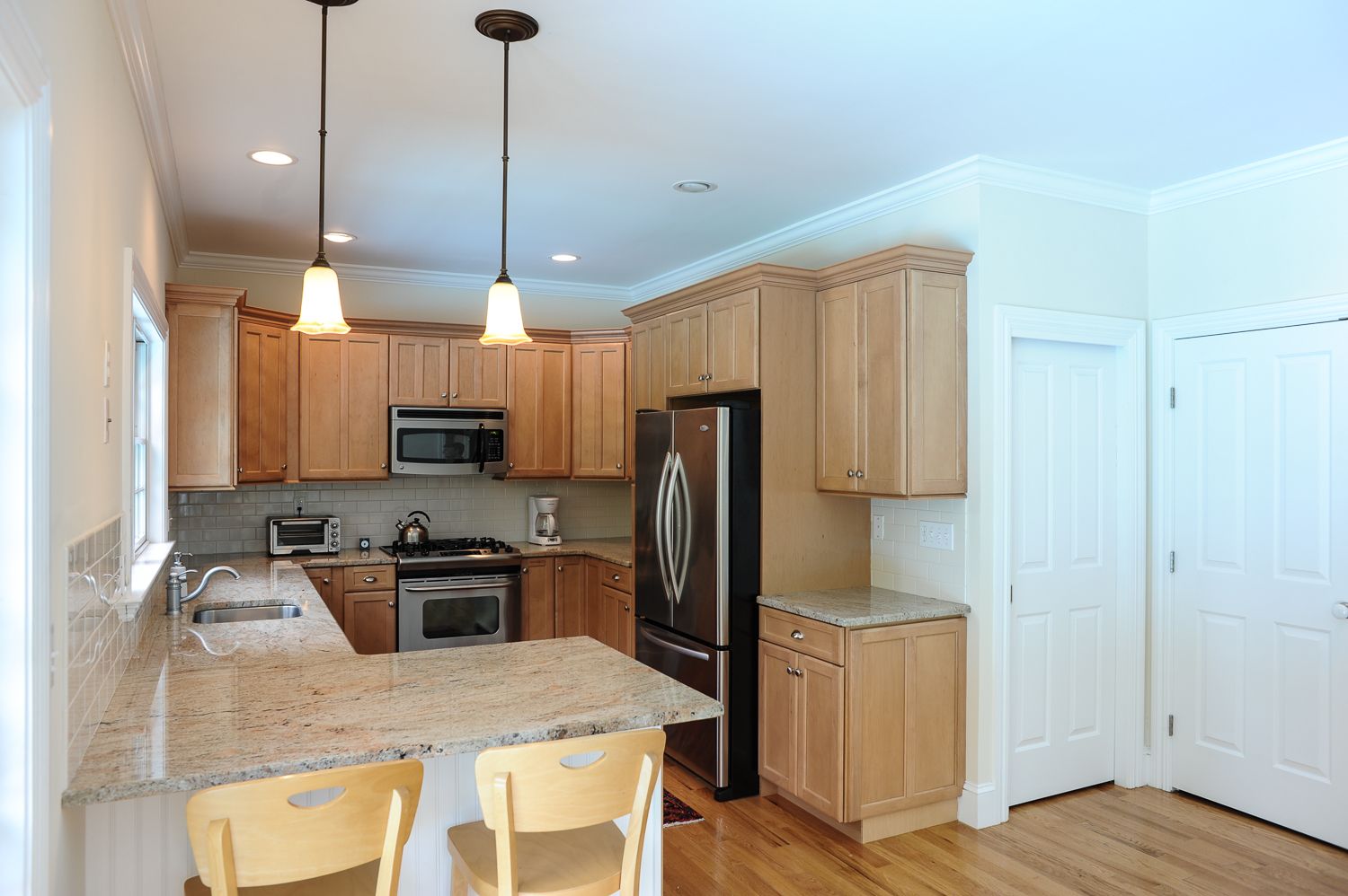  Stylish kitchen with granite countertops, stainless steel appliances, and eating bar