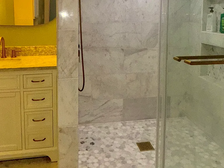 downstairs, marble with brass hardware and accents throughout newly renovated full bathroom