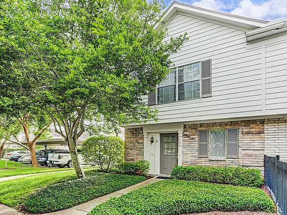 End unit with mature trees and lush landscaping.