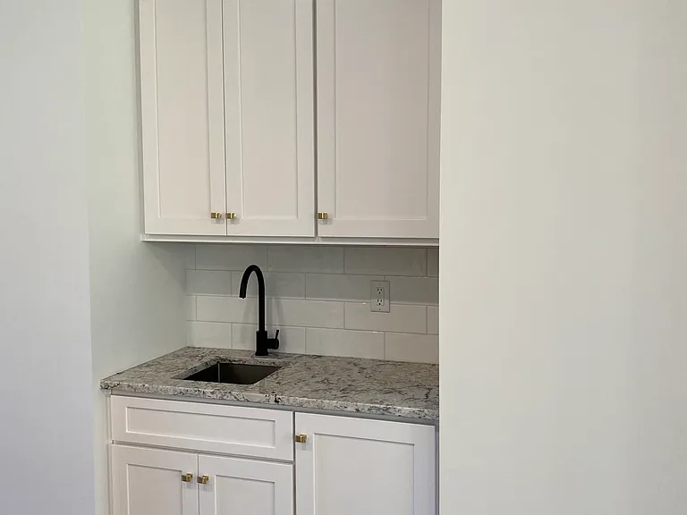 Coffee and tea bar located in kitchen with extra cabinets.