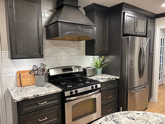 Kitchen with gas range custom hood