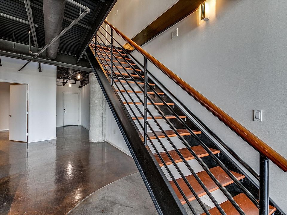 Industrial-inspired staircase featuring wood-finish treads and a metal railing with a wood-finish handrail