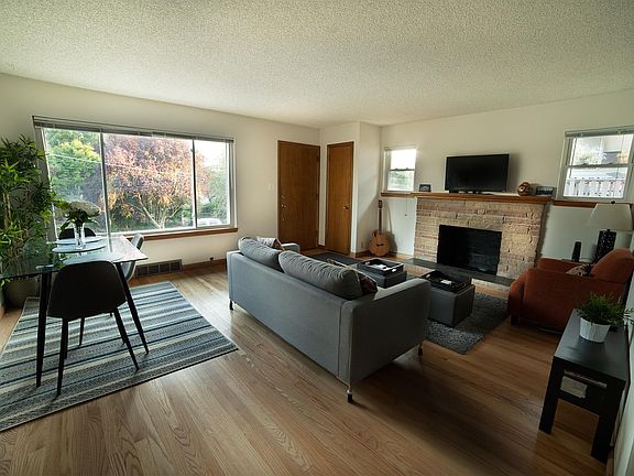 Light-filled picture windows and gorgeous hardwood floors in versatile living.dining area.