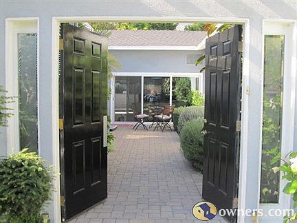 courtyard to main home, past mature shrubs and fountain