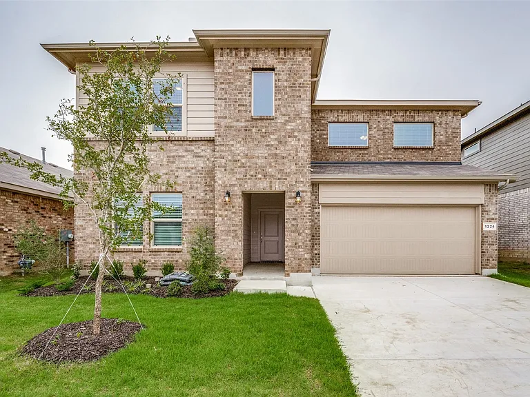 View of front of house with a garage and a front yard