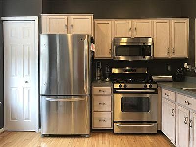 Fully equipped kitchen with stainless steel appliances. Pantry, large refrigerator, microwave, and cook range oven.