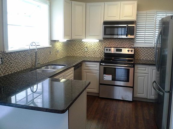 kitchen w/ granite, soft close cabinets, under-mount lighting, disposal, dish washer, stovetop oven microwave, refrigerator with water and ice maker.