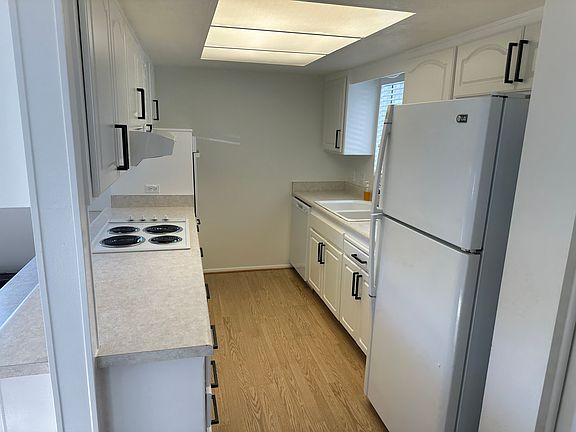 Galley Kitchen with wall oven, electric range, dishwasher, and refrigerator