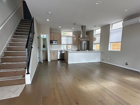Large open concept dining/living area with pantry/storage under stairs